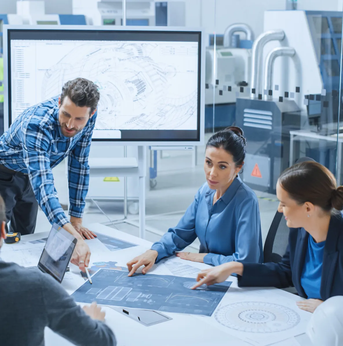 Team discussing blueprints in a modern office.