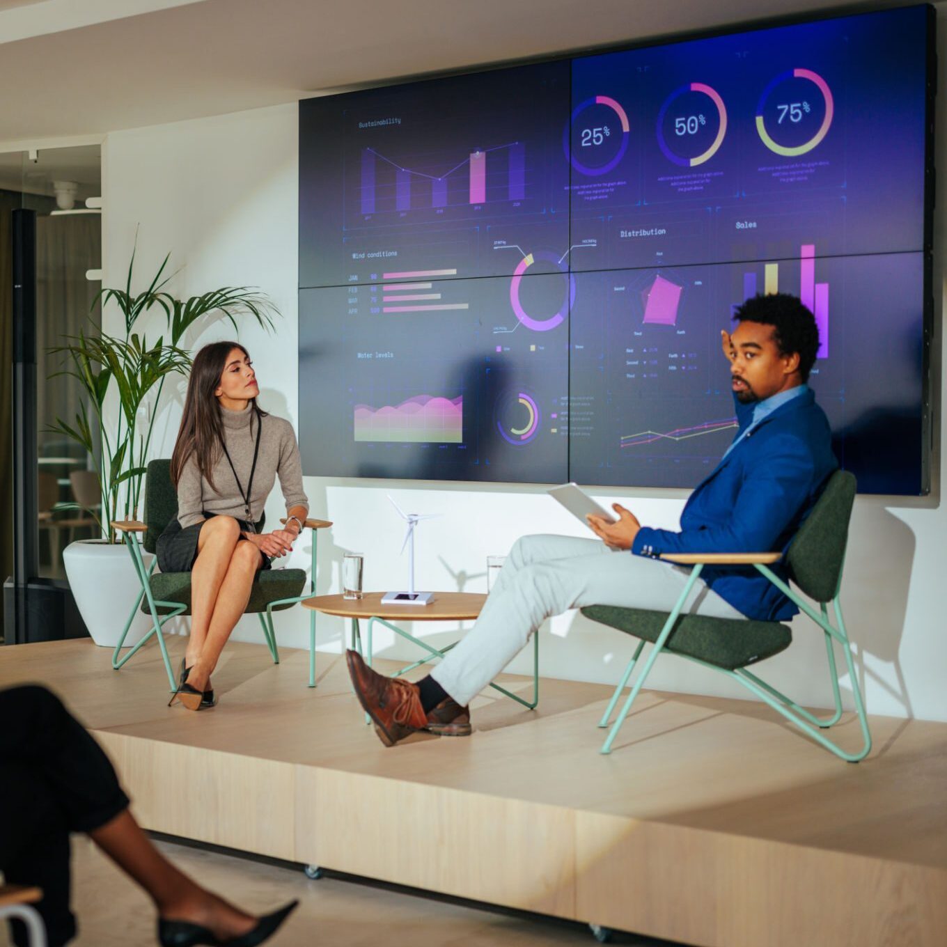 Two people discussing data on screens.